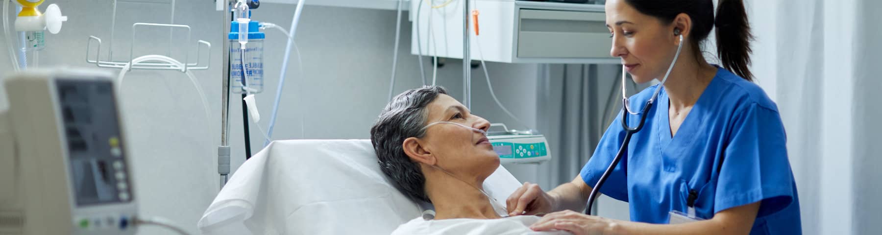 Nurse monitoring a patient receiving care in a hospital room