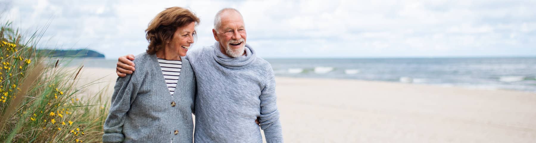 Older couple walking together along a beach