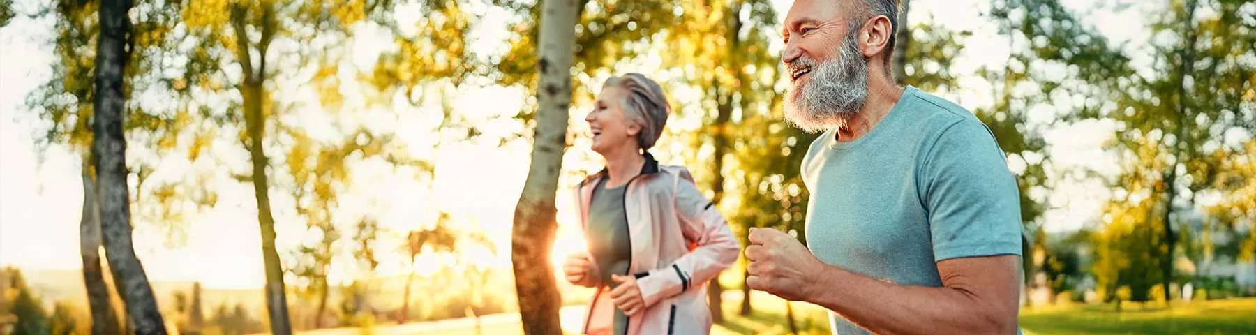 Older couple jogging outdoors on a sunny day